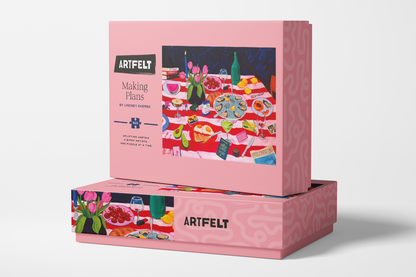 Making Plans jigsaw puzzle packaging box with a colorful illustration of a picnic scene and 'Artfelt' branding.